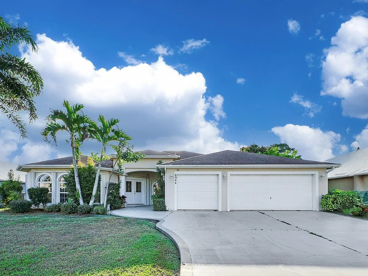 Single-family home with a three-car garage at 6944 NW Daffodil Lane, Port St. Lucie, Florida